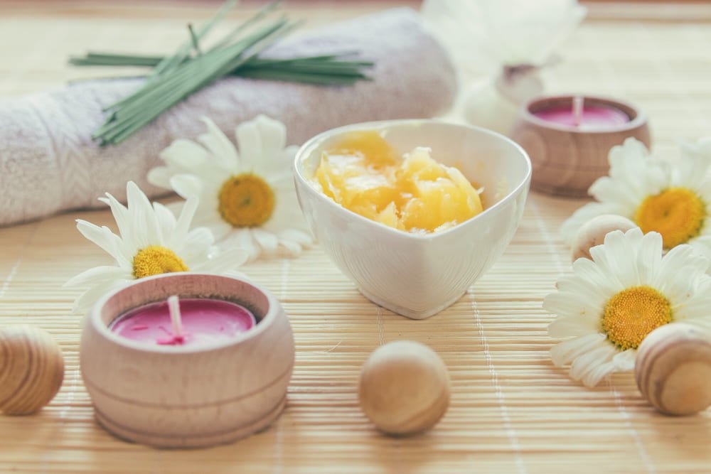 Vela aromática artesanal con flores y aceites esenciales para crear un ambiente de relajación y bienestar.